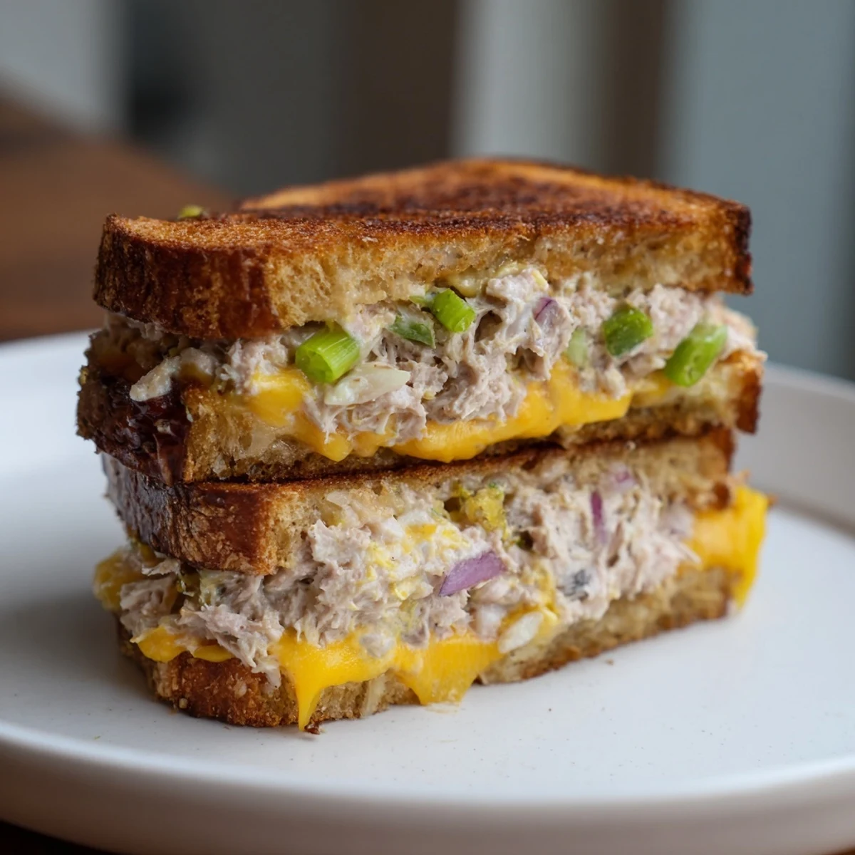 Golden-brown Classic Tuna Melt Sandwich boasts melted cheese, packed tuna salad, and crispy toasted bread.