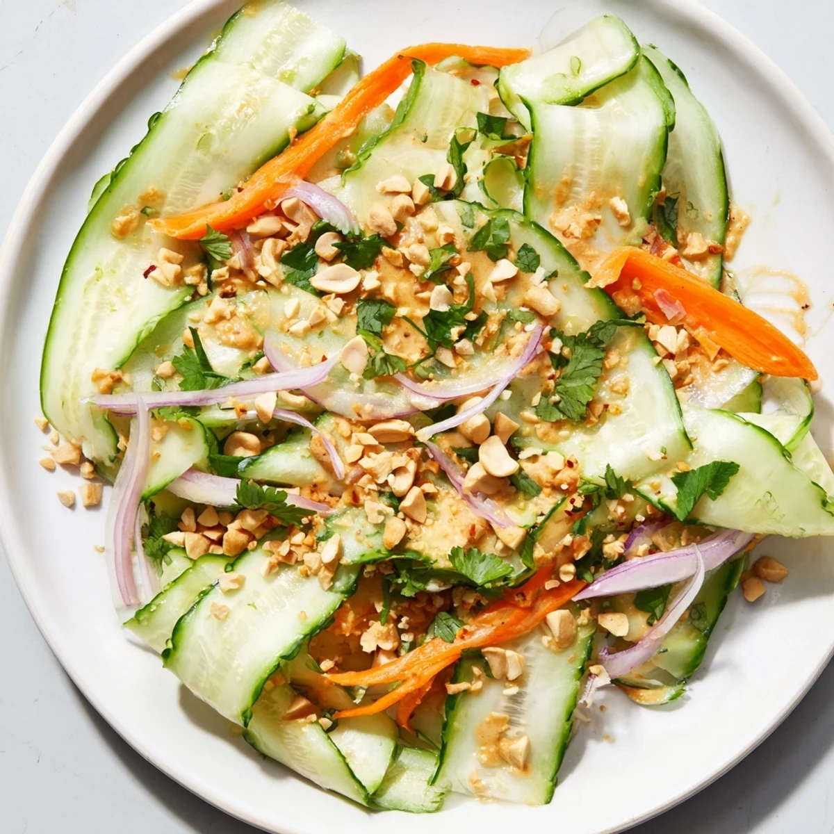 A vibrant overhead shot of Thai-Style Peanut Cucumber Salad, ready for serving with fresh cilantro.