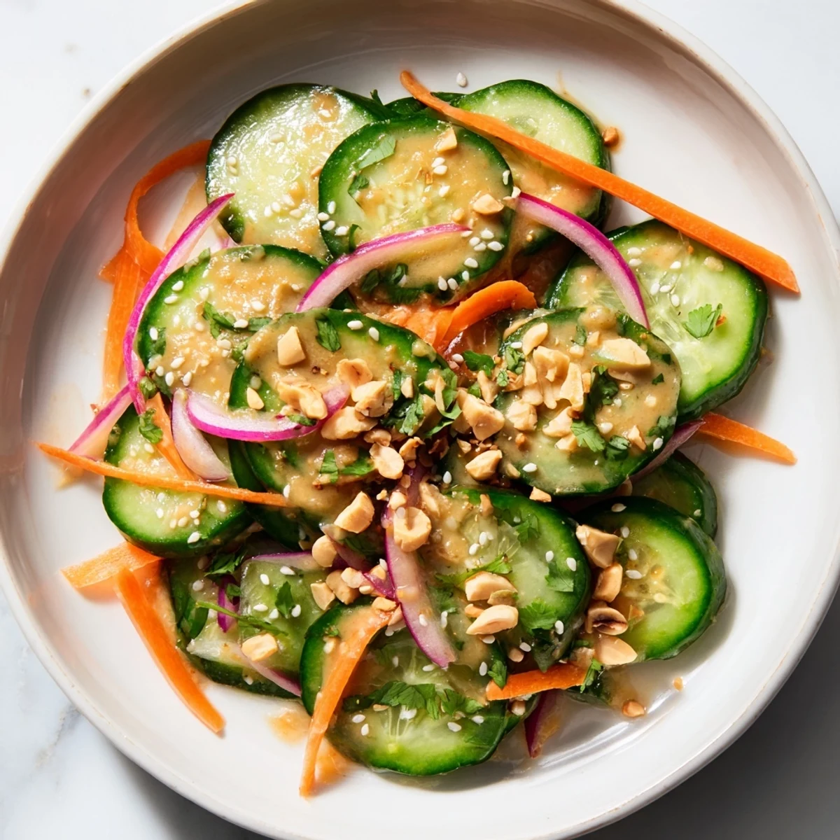 Bright, colorful close-up of Thai-Style Peanut Cucumber Salad showcasing crisp cucumbers and creamy sauce.