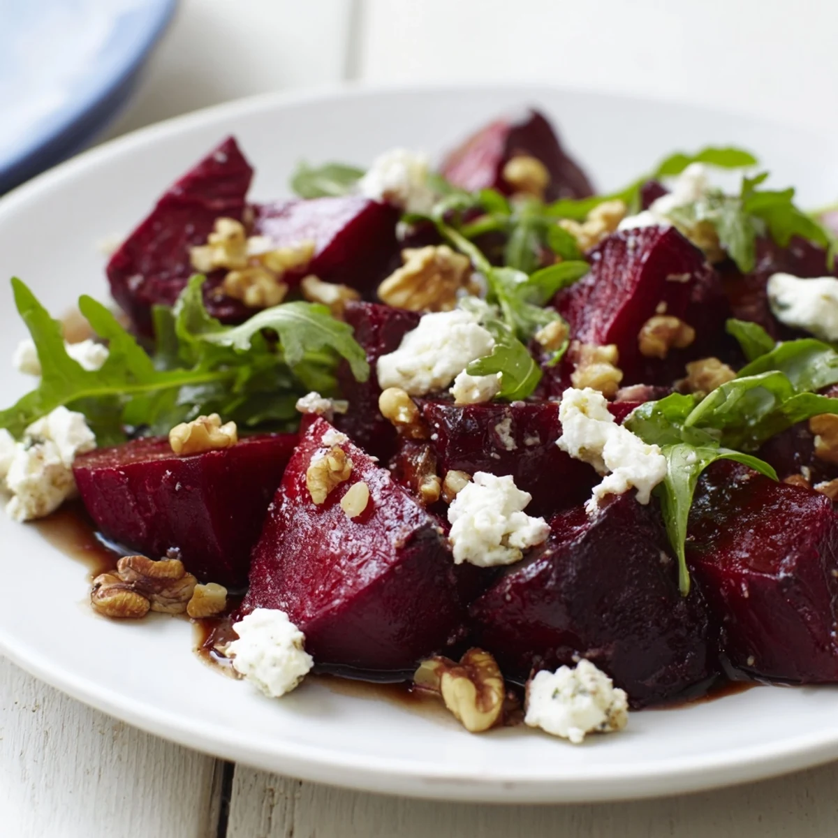 Roasted Beet Goat Cheese Salad with vibrant red beets, creamy cheese crumbles, and toasted walnuts on fresh arugula.  