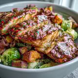 Roasted Brussels sprouts and sweet potatoes add texture beside glazed chicken in this hearty maple Dijon chicken sweet potato bowl.