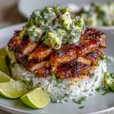 Tangy Honey Lime Chicken & Avocado Rice Stack ready to serve with fresh lime wedges.