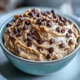 Close-up of fiber-packed chickpea cookie dough dip, showing chocolate chips mixed in.