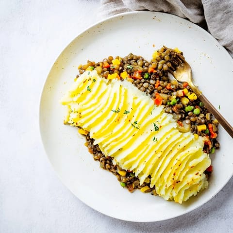Warm, inviting image of Hearty Lentil Shepherds Pie, showcasing the mashed potato crust's texture.