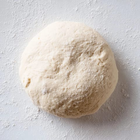 Freshly kneaded homemade pizza dough, inviting you to imagine its delicious flavor before baking.