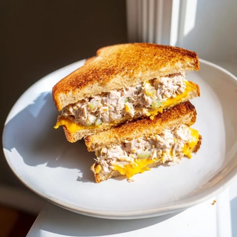 This warm Classic Tuna Melt Sandwich showcases melted cheddar and a delicious creamy tuna filling, perfect lunch.