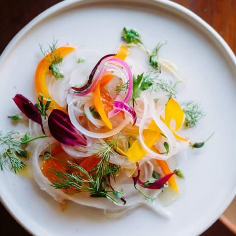 A visually striking "Spinning Top" salad, showing overlapping vegetable ribbons and greens artfully styled.
