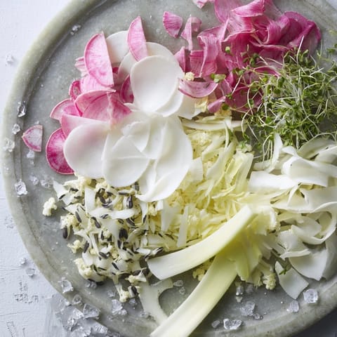 A refreshing The Tundra Trek appetizer highlights crisp daikon and endive, beautifully arranged on cold stone.