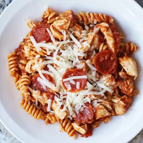 Tender chicken and pepperoni mingle in this vibrant One-Pan Pizza Pasta, a comforting Italian-American meal.