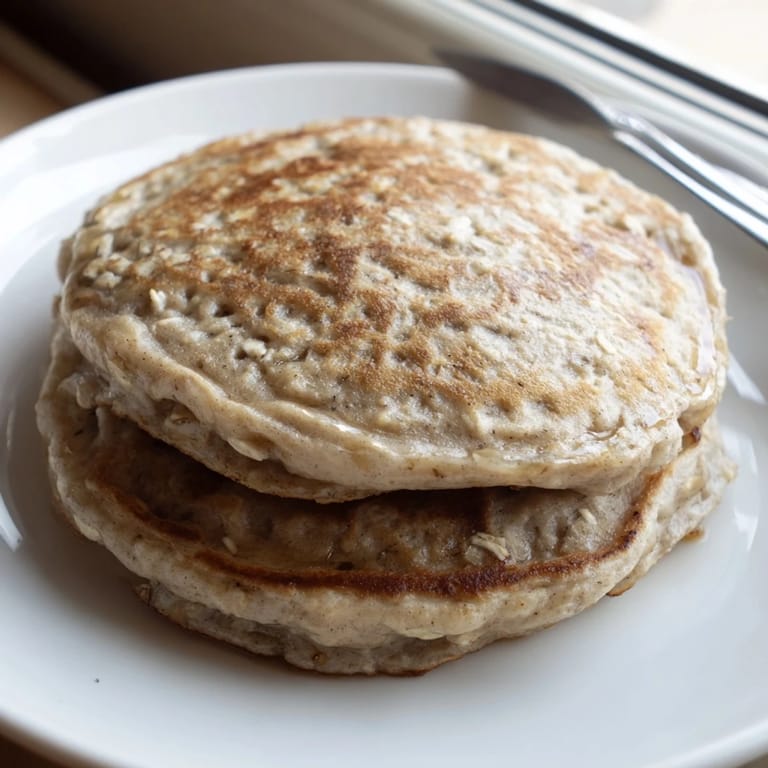 Close-up of freshly cooked banana oat pancakes with visible oat flakes, ready to enjoy.