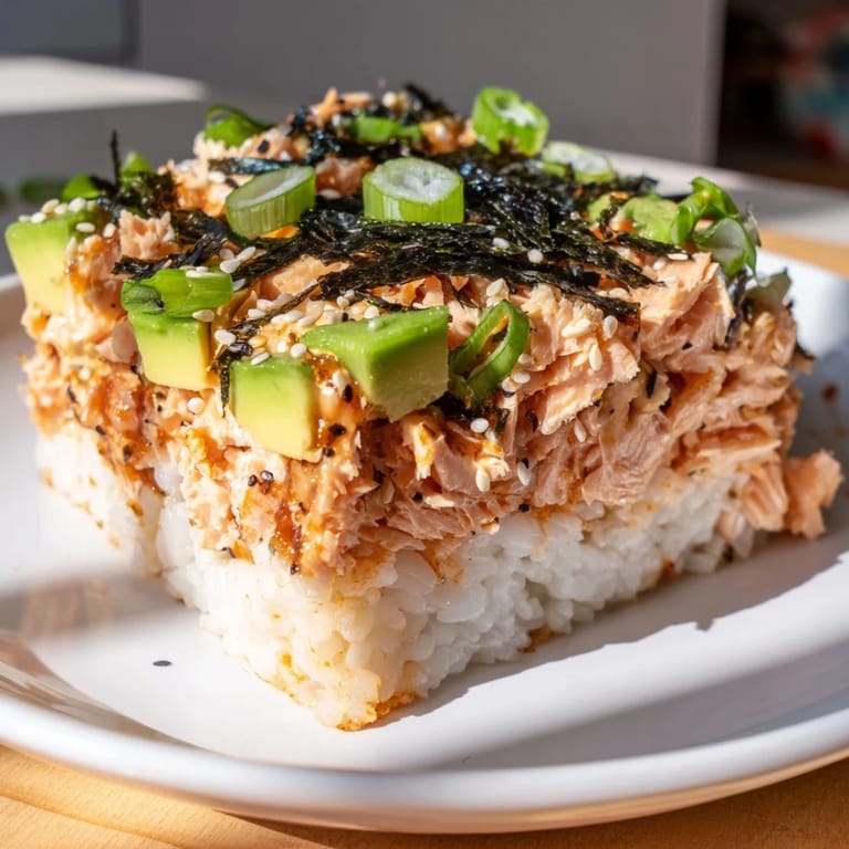 Beautifully layered Sushi Bake Casserole with toasted nori, ready for dipping in savory soy sauce.